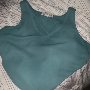 Small, teal tank top with criss-cross front design.